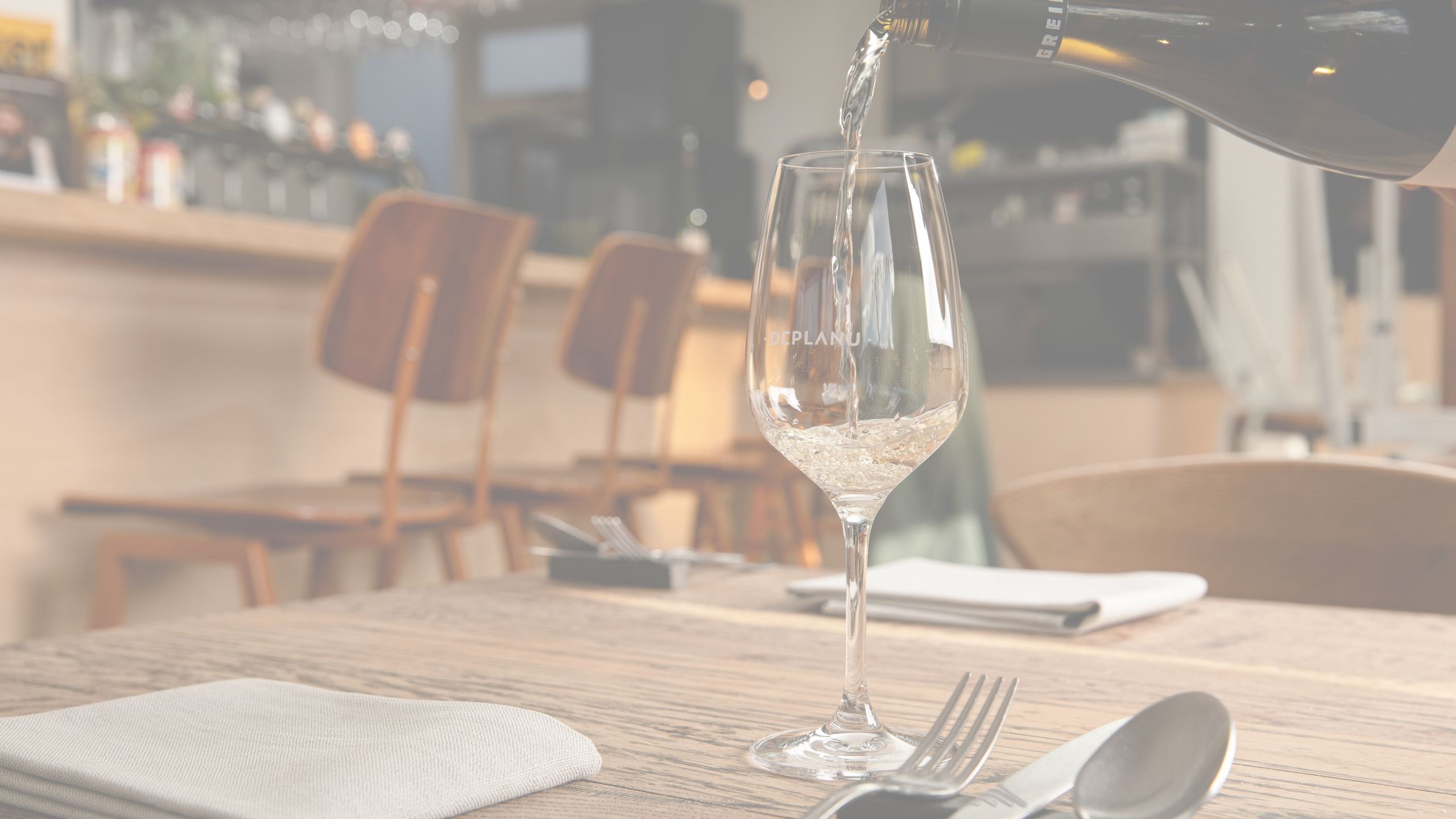 Nagerecht bij zonlicht op hout bij Deplanu, met wijn en bediening aan tafel.